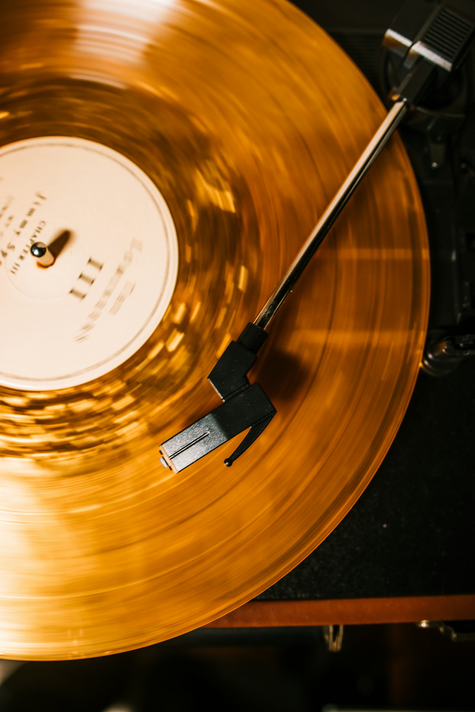 An orange vinyl record spinning on a turntable