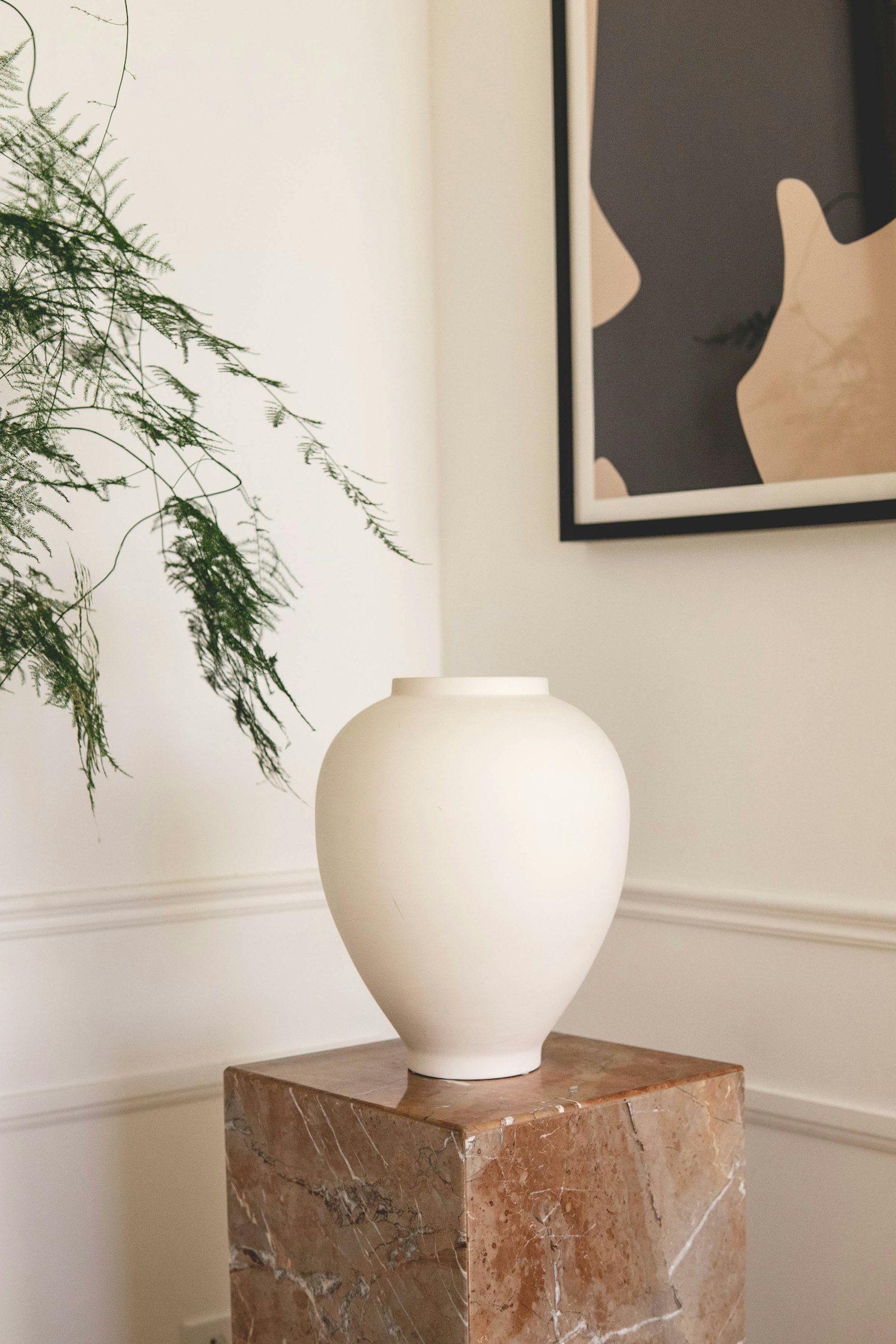 A round white vase on a marble plinth