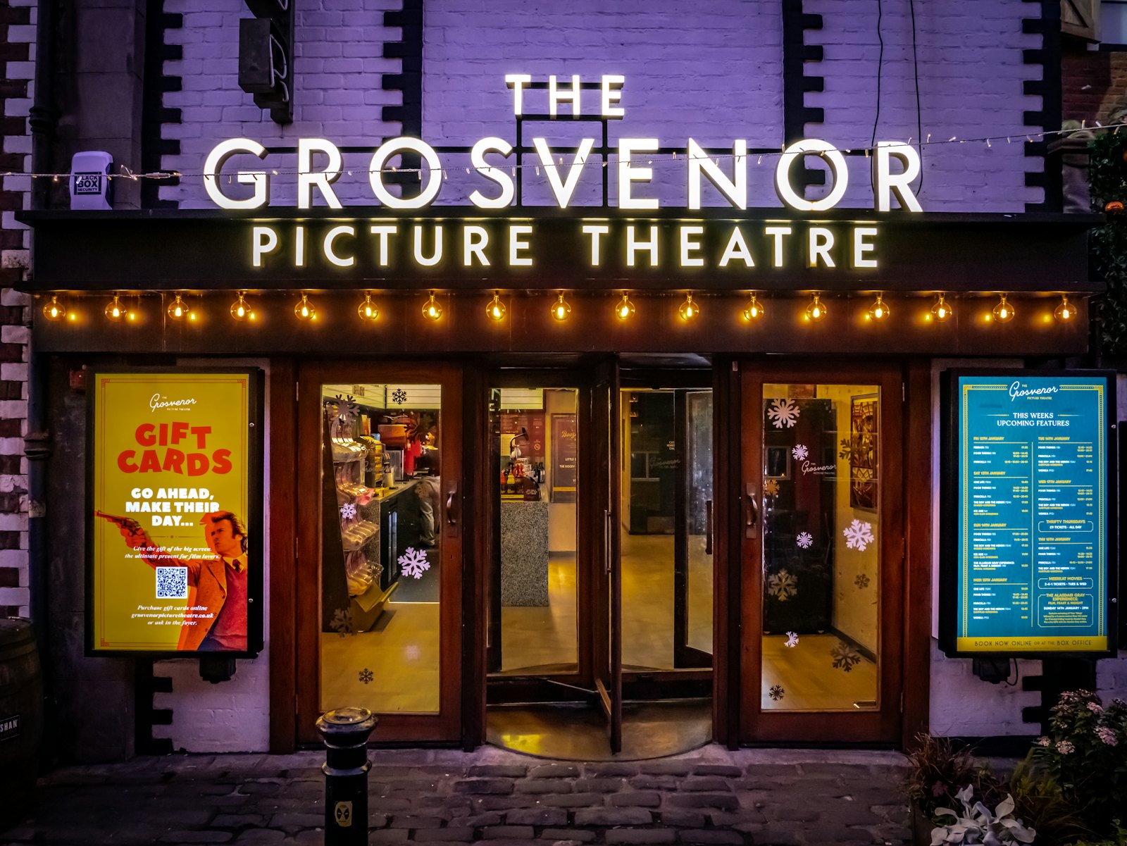 A picture theatre lit up at night