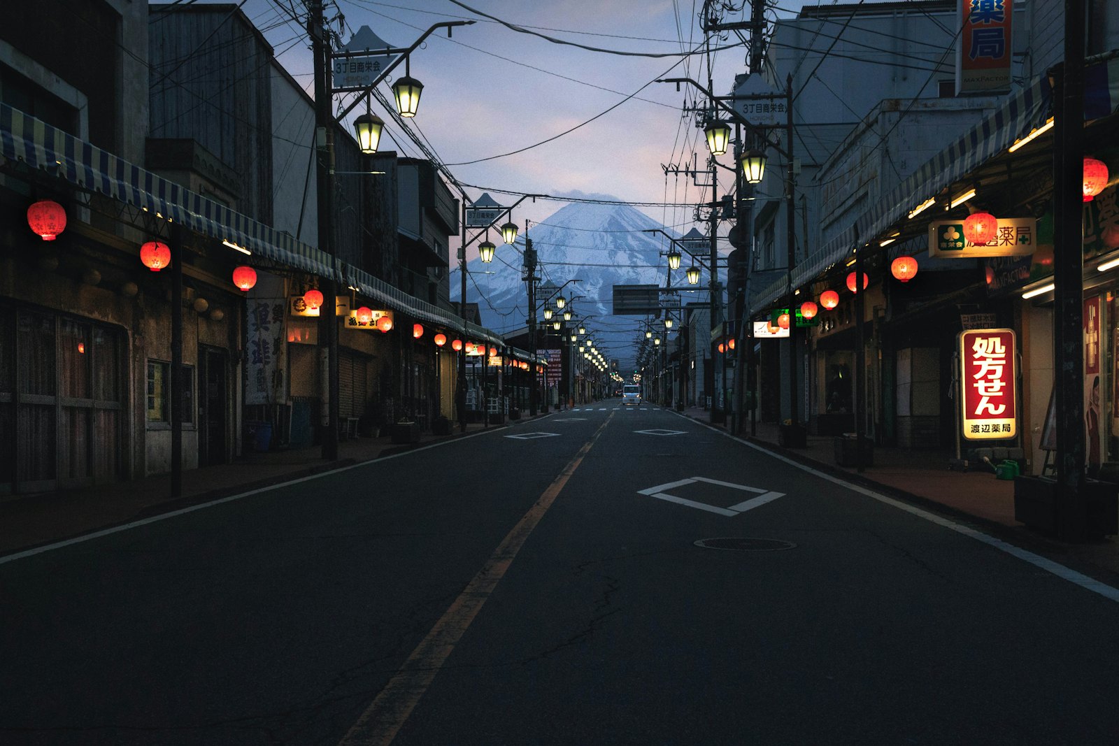 A shopping street at dusk with red lanterns glowing
